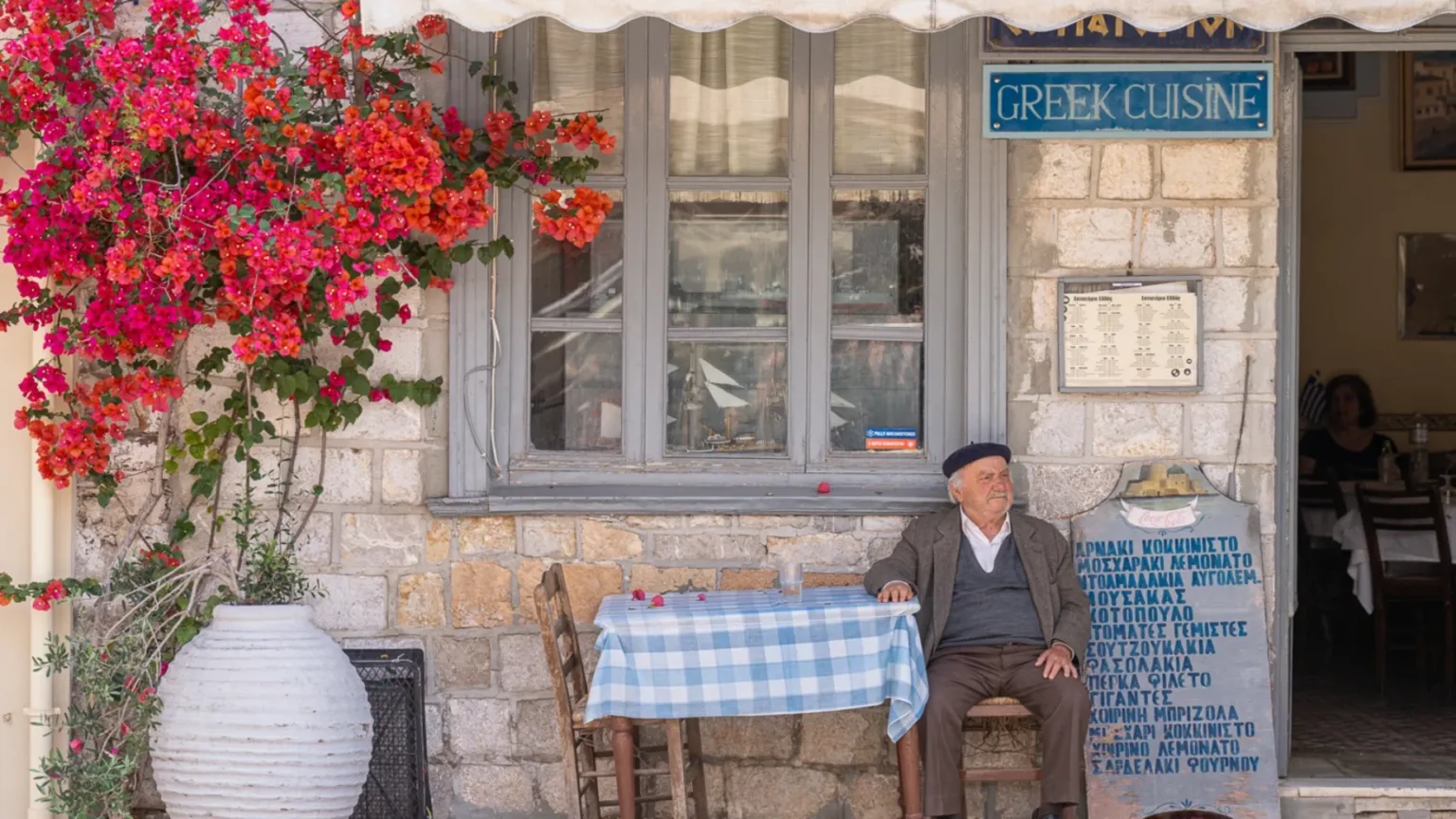 Man sitting at a table with flowers in Nafplio