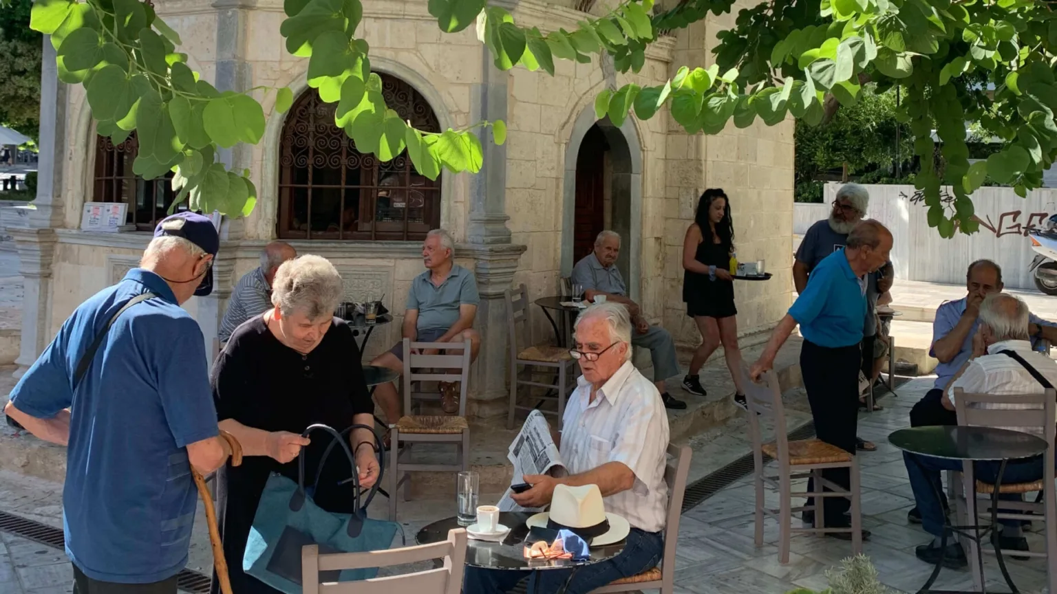 Greek people under the tree in the center of Heraklion in Crete