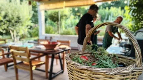 Mand met kruiden op de kookles in Tsagarada