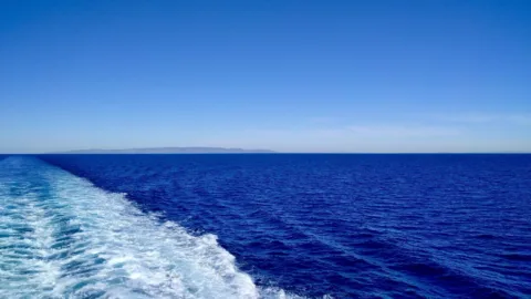 De zee vanaf de boot naar Tinos