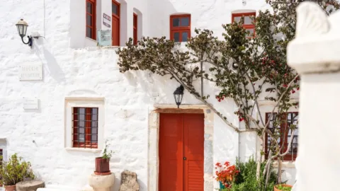 Rode deur bij wit huis op de cycladen