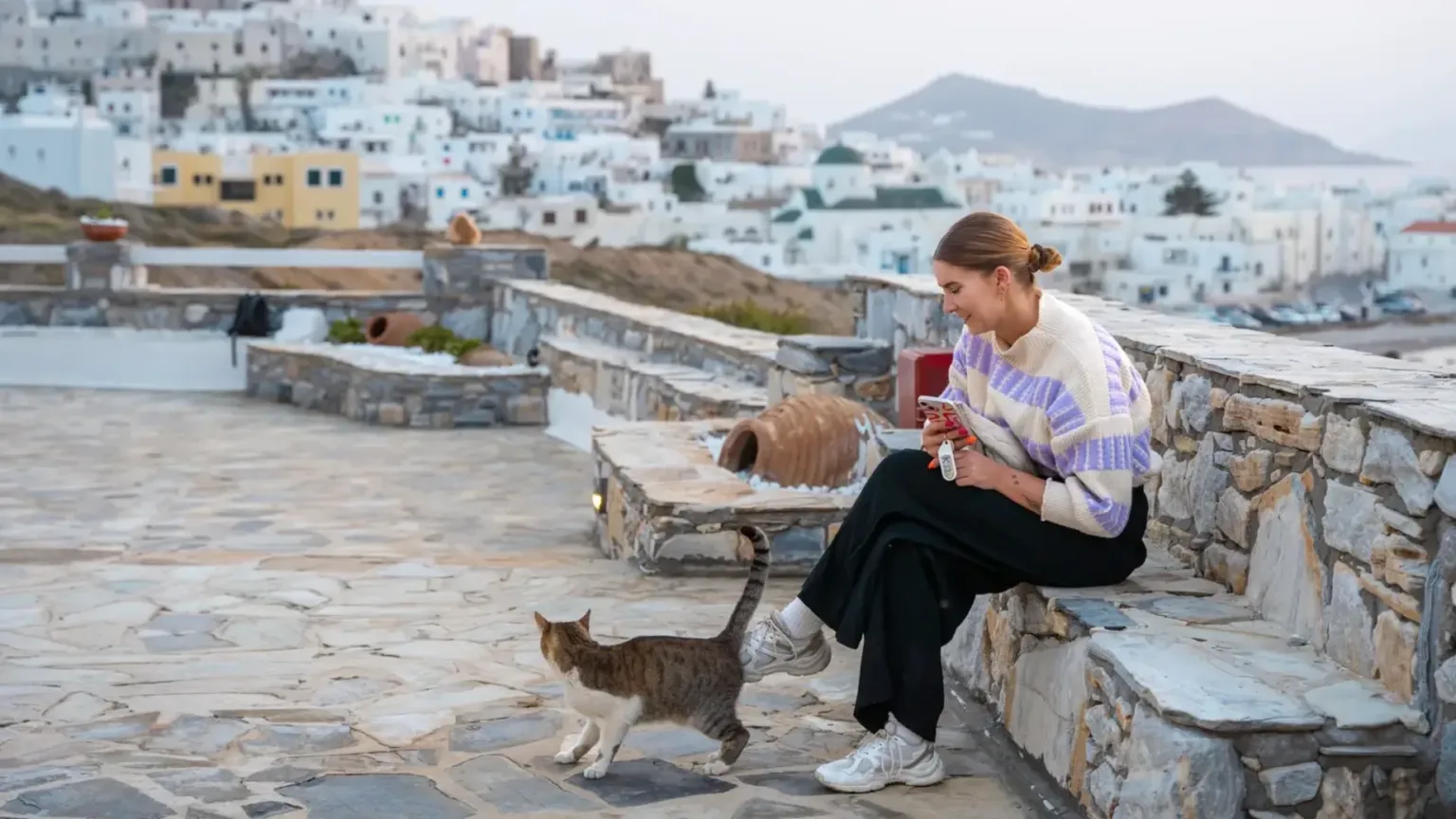 Vrouw op een bankje met kat in Naxos